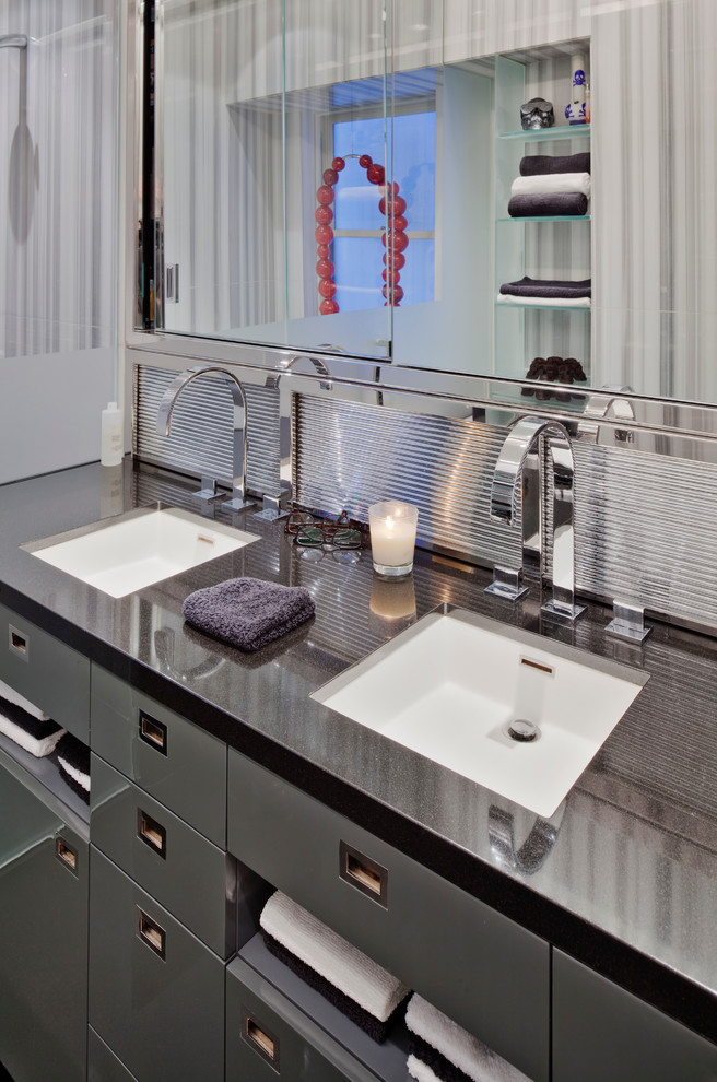 Ejemplo de cuarto de baño principal actual con armarios con paneles lisos, puertas de armario negras y lavabo bajoencimera