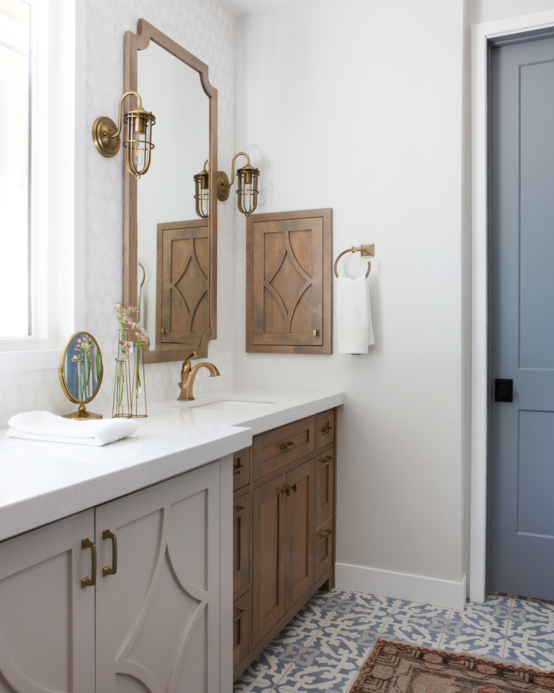 Lantlig inredning av ett mellanstort grå grått en-suite badrum, med cementgolv, ett undermonterad handfat, bänkskiva i kvarts, flerfärgat golv, skåp i mellenmörkt trä, grå väggar och skåp i shakerstil