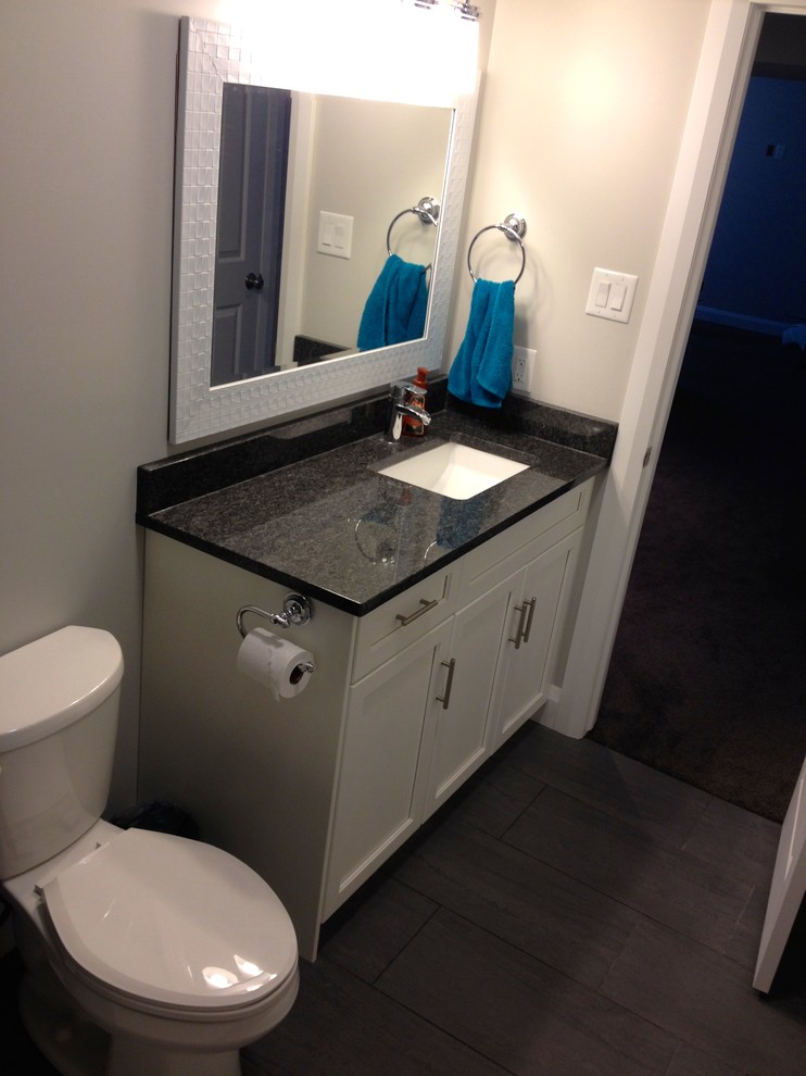 Foto på ett litet amerikanskt badrum, med ett undermonterad handfat, skåp i shakerstil, vita skåp, ett platsbyggt badkar, en dusch i en alkov, en toalettstol med separat cisternkåpa, svart kakel, porslinskakel, grå väggar och klinkergolv i porslin