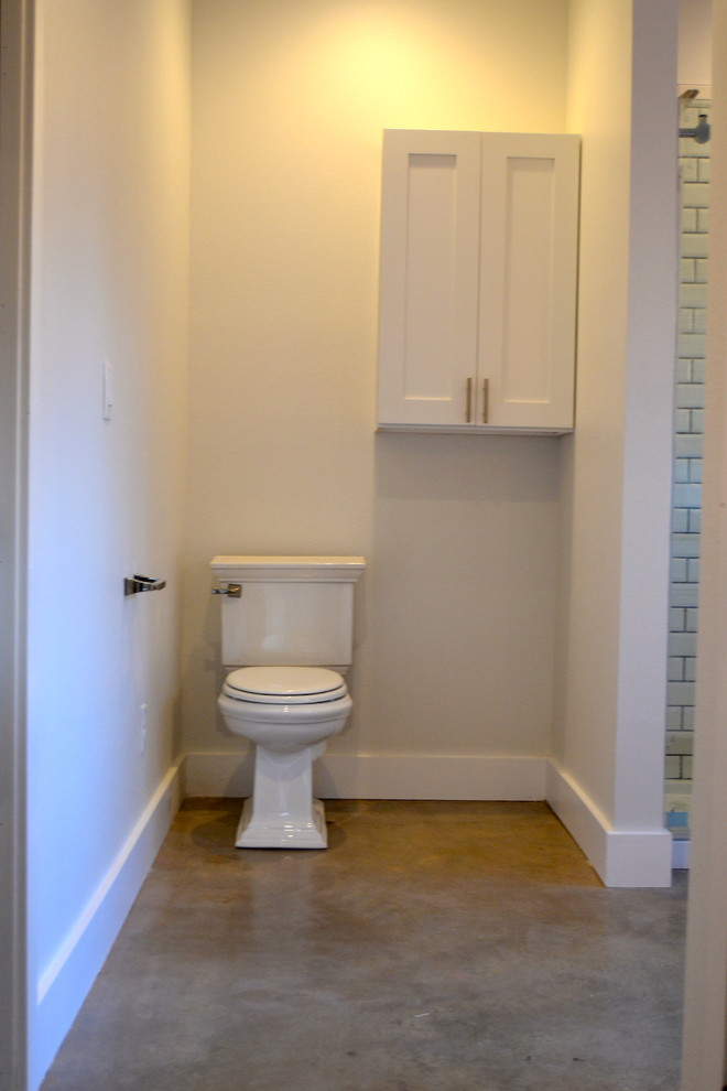 Amerikansk inredning av ett mellanstort en-suite badrum, med ett undermonterad handfat, skåp i shakerstil, vita skåp, marmorbänkskiva, en dusch i en alkov, en toalettstol med separat cisternkåpa, vit kakel, keramikplattor, grå väggar och betonggolv
