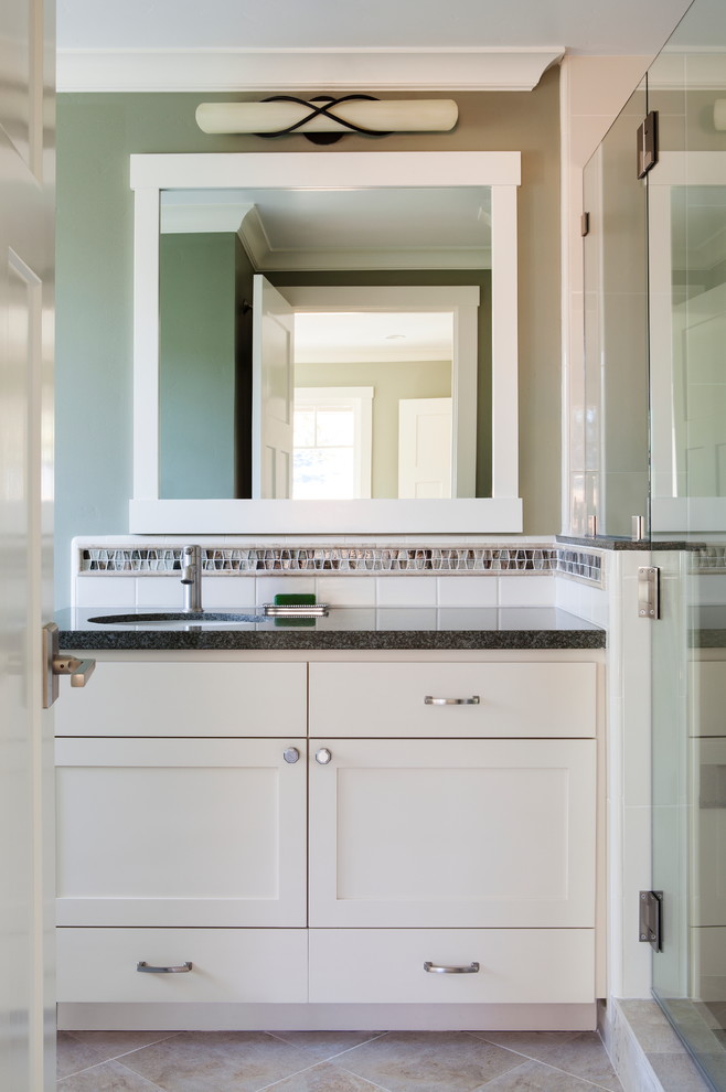 Inredning av ett amerikanskt mellanstort badrum, med skåp i shakerstil, glaskakel, gröna väggar, klinkergolv i porslin, ett undermonterad handfat, bänkskiva i återvunnet glas, vita skåp, en dusch i en alkov och flerfärgad kakel