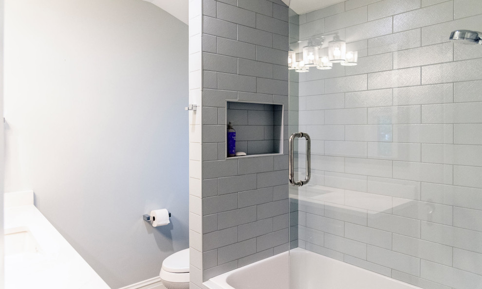 Idéer för att renovera ett litet amerikanskt vit vitt badrum för barn, med möbel-liknande, grå skåp, ett badkar i en alkov, en dusch/badkar-kombination, en toalettstol med hel cisternkåpa, blå kakel, porslinskakel, grå väggar, mosaikgolv, ett undermonterad handfat, bänkskiva i kvarts, flerfärgat golv och dusch med gångjärnsdörr