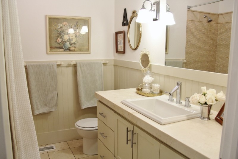 Idéer för amerikanska badrum, med ett nedsänkt handfat, skåp i shakerstil, beige skåp, marmorbänkskiva, en dusch/badkar-kombination, beige kakel, stenkakel, vita väggar och marmorgolv