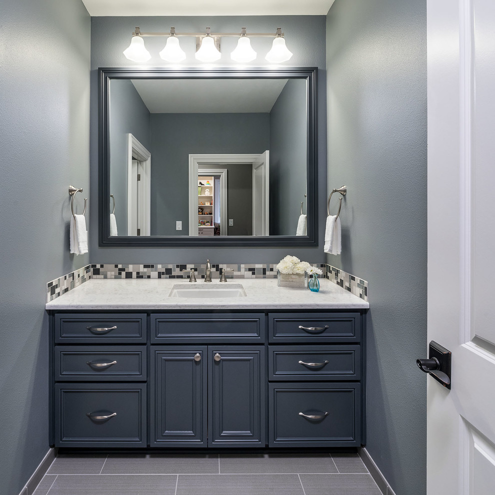 Foto på ett stort amerikanskt badrum för barn, med luckor med infälld panel, blå skåp, blå kakel, mosaik, blå väggar, cementgolv, ett undermonterad handfat, bänkskiva i kvartsit och grått golv