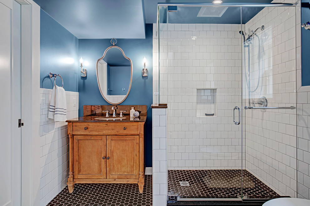 Cette image montre une salle d'eau craftsman de taille moyenne avec un placard en trompe-l'oeil, des portes de placard marrons, une douche d'angle, WC séparés, un carrelage blanc, des carreaux de céramique, un mur bleu, un sol en carrelage de céramique, un lavabo posé, un plan de toilette en quartz modifié, un sol noir, une cabine de douche à porte battante et un plan de toilette marron.