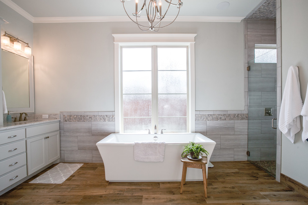 Exempel på ett stort lantligt en-suite badrum, med skåp i shakerstil, ett fristående badkar, en kantlös dusch, grå kakel, cementkakel, grå väggar, klinkergolv i keramik, ett undermonterad handfat, marmorbänkskiva och vita skåp