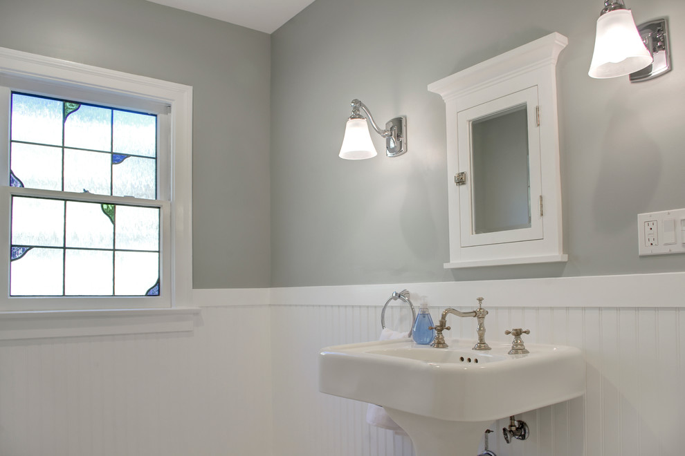 На фото: главная ванная комната среднего размера в стиле кантри с раковиной с пьедесталом, угловой ванной, душем над ванной, раздельным унитазом, белой плиткой, серыми стенами, мраморным полом, фасадами в стиле шейкер и белыми фасадами