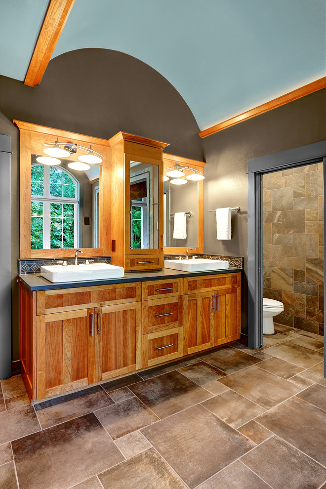 Пример оригинального дизайна: большая главная ванная комната в стиле кантри с фасадами в стиле шейкер, светлыми деревянными фасадами, раздельным унитазом, разноцветной плиткой, керамогранитной плиткой, коричневыми стенами, полом из керамогранита, настольной раковиной и столешницей из искусственного кварца