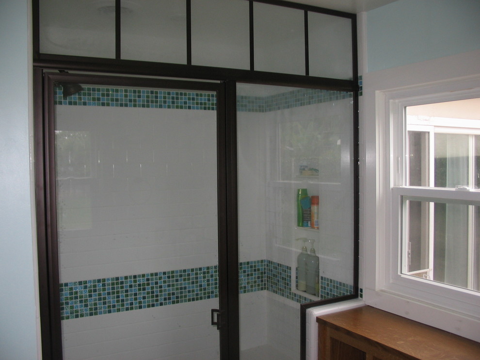 Пример оригинального дизайна: ванная комната среднего размера в стиле кантри с плоскими фасадами, фасадами цвета дерева среднего тона, душем в нише, раздельным унитазом, синей плиткой, плиткой мозаикой, белыми стенами, полом из керамической плитки, душевой кабиной, монолитной раковиной, стеклянной столешницей, коричневым полом и душем с распашными дверями