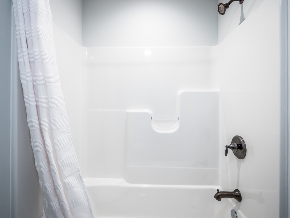 Ispirazione per una stanza da bagno con doccia stile americano di medie dimensioni con ante lisce, ante marroni, doccia ad angolo, piastrelle beige, piastrelle grigie, piastrelle in pietra, pareti grigie, lavabo da incasso e top in superficie solida