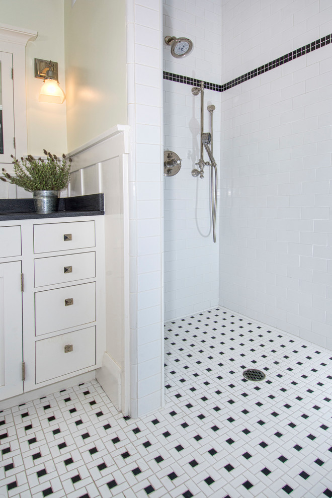 Inredning av ett amerikanskt svart svart badrum, med skåp i shakerstil, vita skåp, ett badkar i en alkov, svart och vit kakel, keramikplattor, mosaikgolv, ett undermonterad handfat, granitbänkskiva och vitt golv