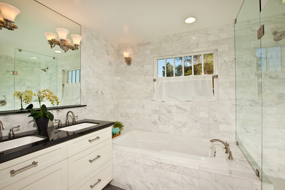 На фото: ванная комната в современном стиле с белыми фасадами, накладной ванной, душем в нише, белой плиткой и мраморной плиткой