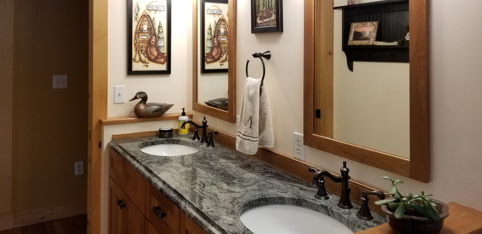 Example of a small arts and crafts master ceramic tile and multicolored floor bathroom design in Boston with shaker cabinets, medium tone wood cabinets, a two-piece toilet, yellow walls, an undermount sink, granite countertops and green countertops