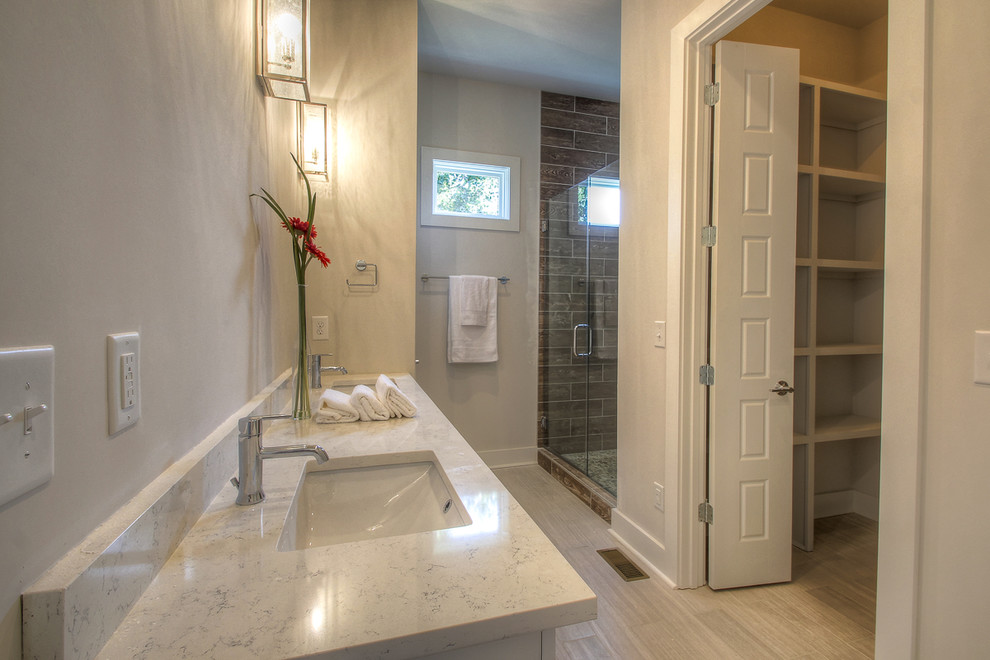 Пример оригинального дизайна: ванная комната среднего размера в стиле неоклассика (современная классика) с плоскими фасадами, белыми фасадами, душем в нише, коричневой плиткой, керамогранитной плиткой, серыми стенами, полом из керамогранита, душевой кабиной, врезной раковиной и столешницей из кварцита