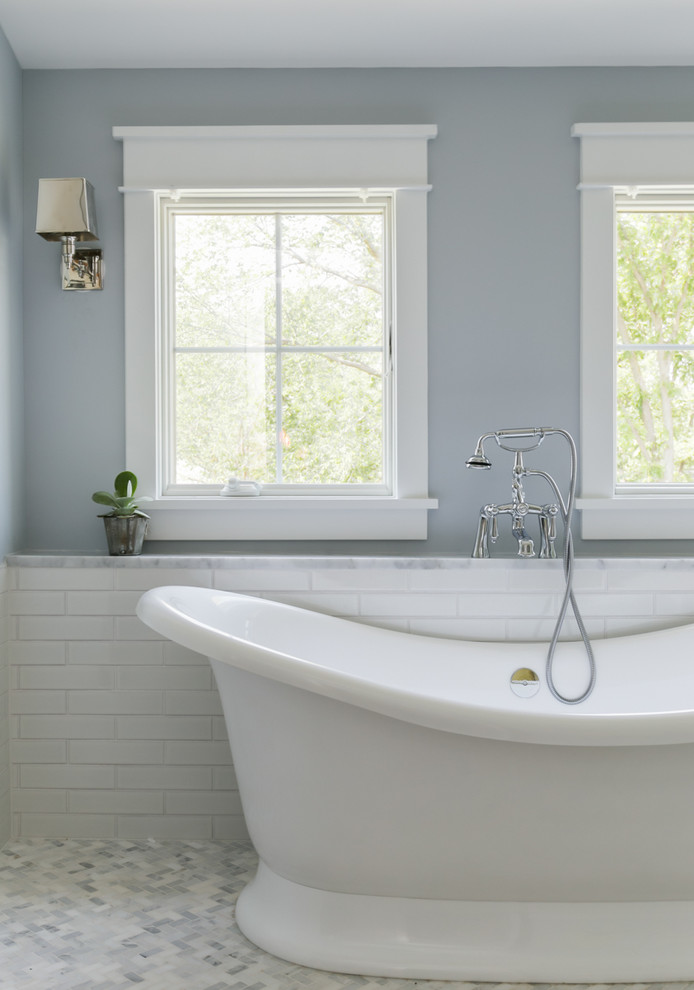 Inredning av ett klassiskt en-suite badrum, med ett undermonterad handfat, luckor med infälld panel, svarta skåp, ett badkar med tassar och grå väggar
