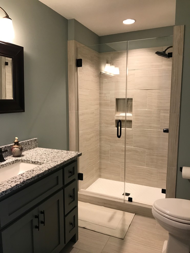 Bild på ett mellanstort vintage badrum med dusch, med skåp i shakerstil, grå skåp, en dusch i en alkov, en toalettstol med hel cisternkåpa, porslinskakel, grå väggar, klinkergolv i porslin, ett undermonterad handfat, granitbänkskiva och dusch med skjutdörr