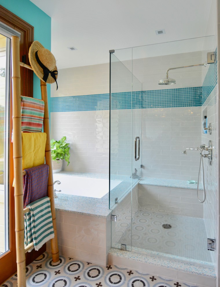 Medelhavsstil inredning av ett mellanstort badrum för barn, med möbel-liknande, grå skåp, ett platsbyggt badkar, en dusch i en alkov, en toalettstol med separat cisternkåpa, blå kakel, glasskiva, blå väggar, cementgolv, ett undermonterad handfat, bänkskiva i återvunnet glas, blått golv och dusch med gångjärnsdörr