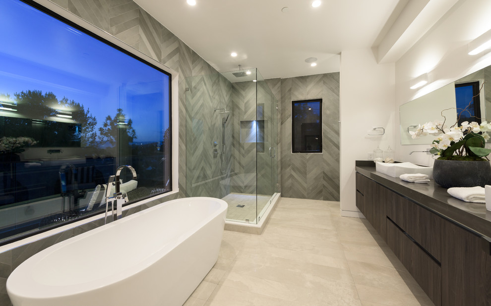 Large minimalist master gray tile and marble tile travertine floor and beige floor bathroom photo in Los Angeles with gray walls, flat-panel cabinets, dark wood cabinets, a vessel sink and a hinged shower door