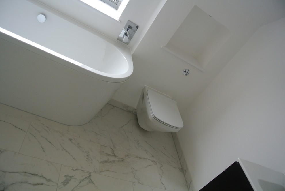 Свежая идея для дизайна: главная ванная комната среднего размера в современном стиле с черными фасадами, отдельно стоящей ванной, открытым душем, инсталляцией, белой плиткой, белыми стенами и подвесной раковиной - отличное фото интерьера