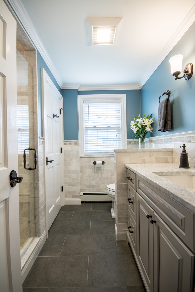 Alcove shower - mid-sized traditional 3/4 white tile and subway tile porcelain tile alcove shower idea in Providence with raised-panel cabinets, gray cabinets, a two-piece toilet, blue walls, an undermount sink and marble countertops