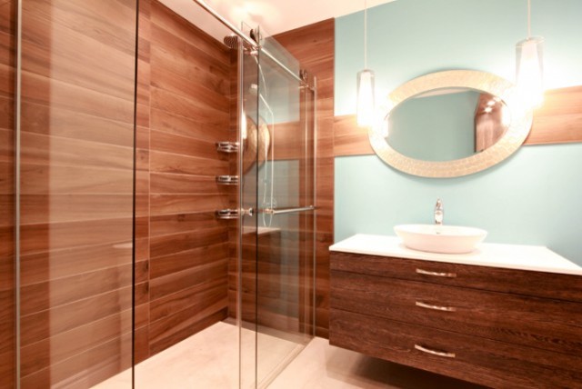 This is an example of a large modern ensuite bathroom in Montreal with flat-panel cabinets, dark wood cabinets, an alcove shower, brown walls, a vessel sink and a sliding door.
