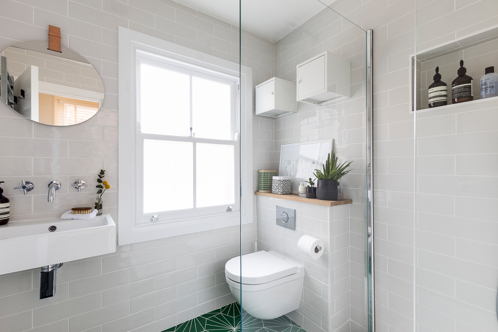 На фото: маленькая ванная комната в современном стиле с открытым душем, инсталляцией, белой плиткой, керамической плиткой, белыми стенами, полом из керамической плитки, душевой кабиной, подвесной раковиной, зеленым полом и открытым душем для на участке и в саду