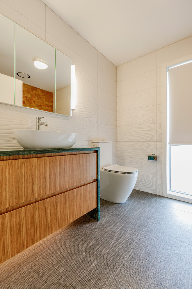 Kleines Modernes Badezimmer En Suite mit verzierten Schränken, weißen Schränken, freistehender Badewanne, Toilette mit Aufsatzspülkasten, weißen Fliesen, Keramikfliesen, weißer Wandfarbe, Porzellan-Bodenfliesen, Aufsatzwaschbecken, Granit-Waschbecken/Waschtisch, braunem Boden und grüner Waschtischplatte in Auckland