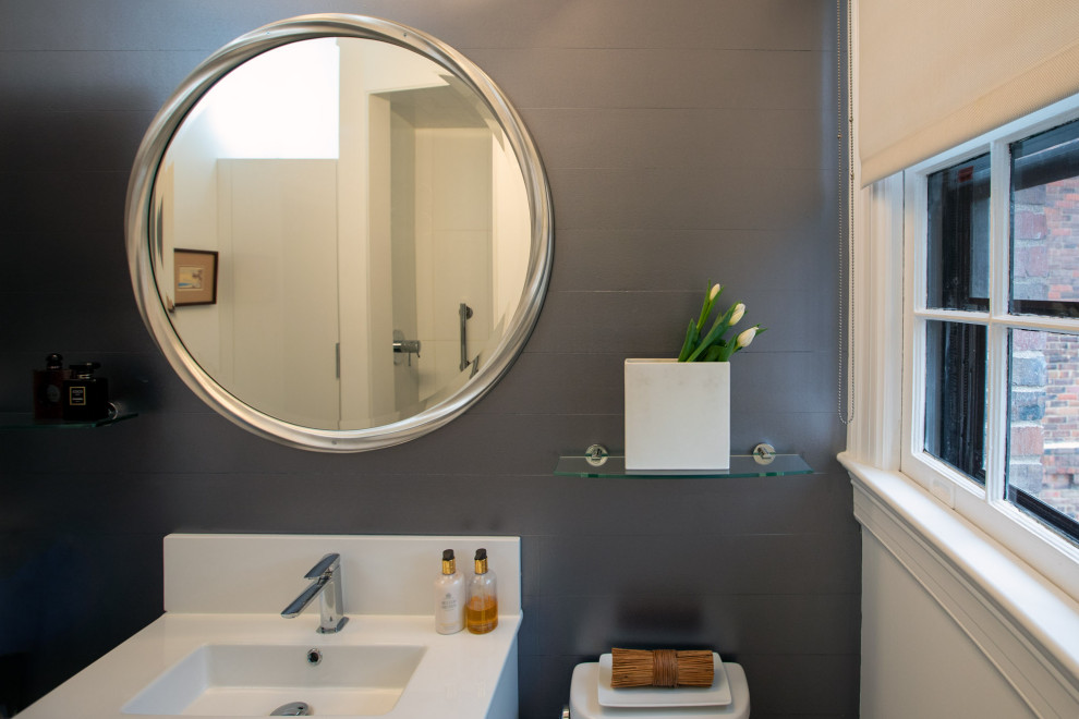 Inredning av ett modernt litet vit vitt badrum med dusch, med släta luckor, vita skåp, en hörndusch, en toalettstol med separat cisternkåpa, vit kakel, porslinskakel, grå väggar, klinkergolv i keramik, ett väggmonterat handfat, bänkskiva i akrylsten, grått golv och med dusch som är öppen