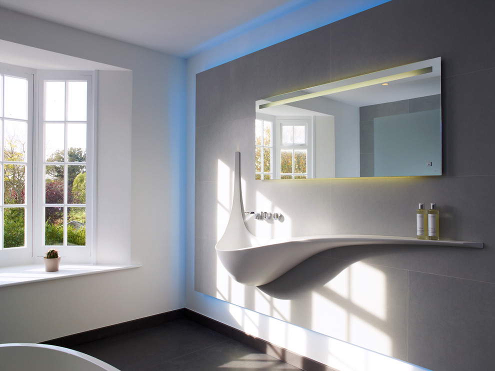 Immagine di una stanza da bagno padronale moderna di medie dimensioni con vasca freestanding, doccia aperta, piastrelle grigie, piastrelle in ceramica, WC sospeso, pareti grigie e pavimento in gres porcellanato
