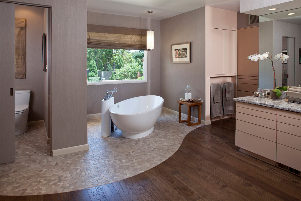 Modernes Badezimmer mit freistehender Badewanne und Kiesel-Bodenfliesen in Sonstige