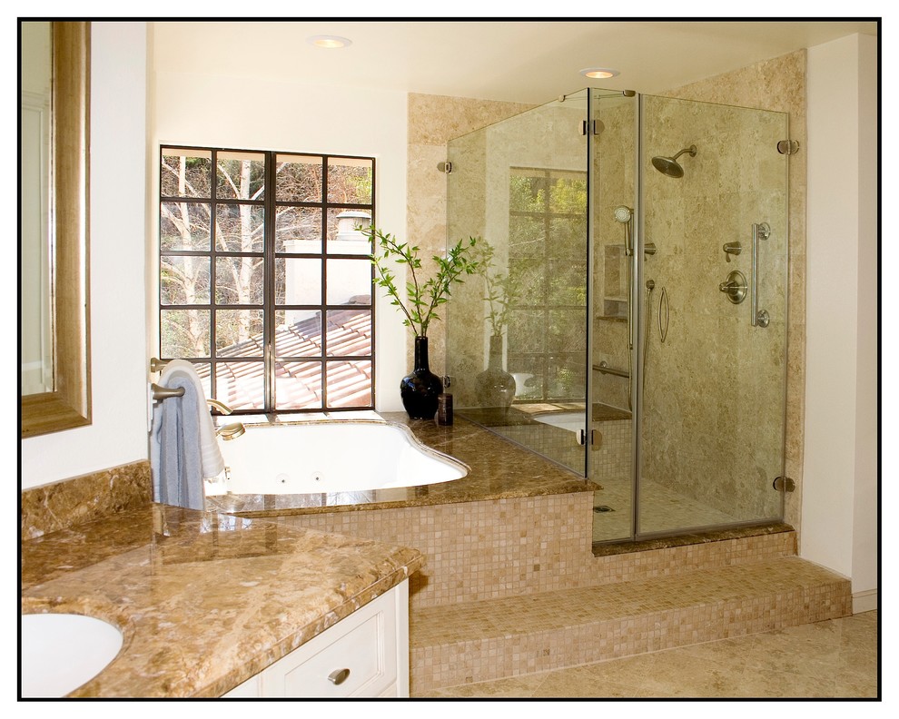 Cette image montre une salle de bain design avec un lavabo encastré, une douche d'angle, un mur beige et un sol en travertin.
