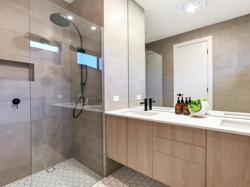 This is an example of a medium sized contemporary shower room bathroom in Adelaide with freestanding cabinets, medium wood cabinets, a corner shower, a one-piece toilet, brown tiles, porcelain tiles, brown walls, porcelain flooring, a built-in sink, quartz worktops, white floors, a hinged door and white worktops.