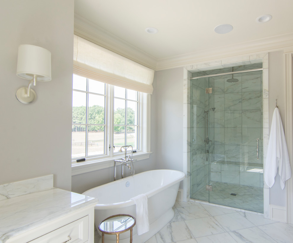 This is an example of a medium sized eclectic ensuite bathroom in Raleigh with recessed-panel cabinets, white cabinets, a freestanding bath, an alcove shower, white tiles, marble tiles, grey walls, marble flooring, a submerged sink, marble worktops, white floors and a hinged door.