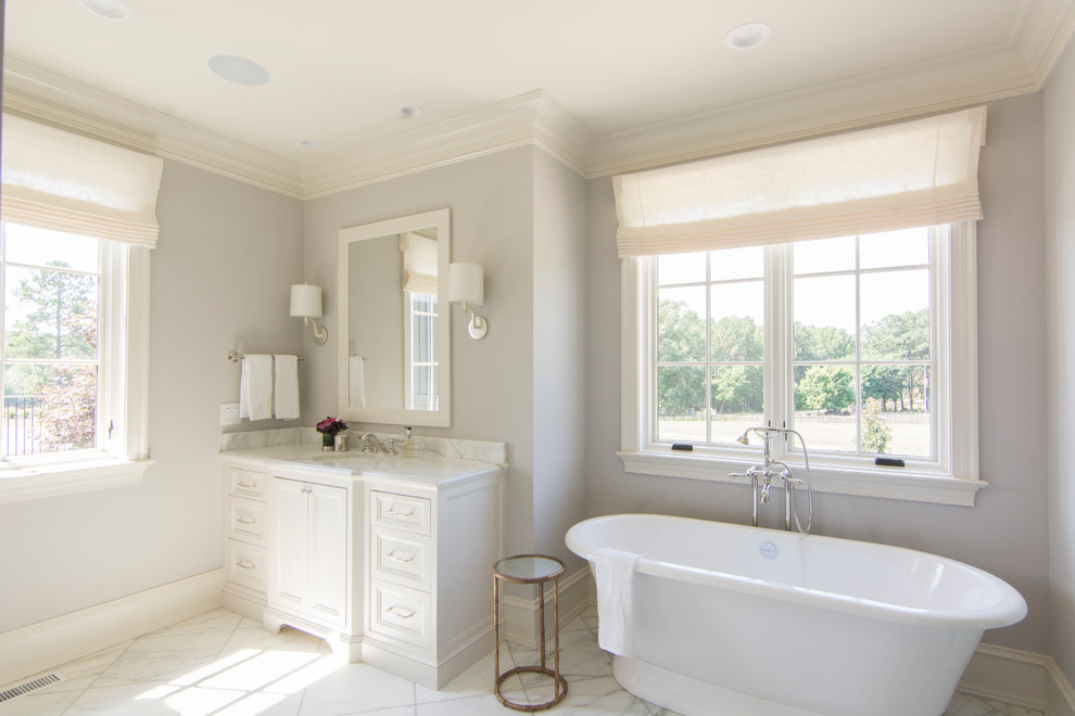 Inspiration for a medium sized classic ensuite bathroom in Raleigh with recessed-panel cabinets, white cabinets, a freestanding bath, grey walls, marble flooring, a submerged sink, marble worktops, white floors, an alcove shower, white tiles, marble tiles and a hinged door.