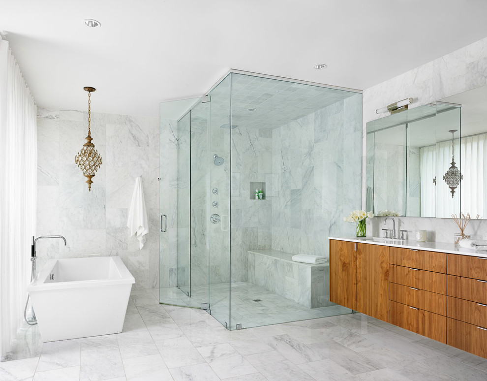 Large contemporary bathroom in Austin with a submerged sink, flat-panel cabinets, marble worktops, a freestanding bath, a corner shower, white tiles, stone tiles, white walls, marble flooring and medium wood cabinets.