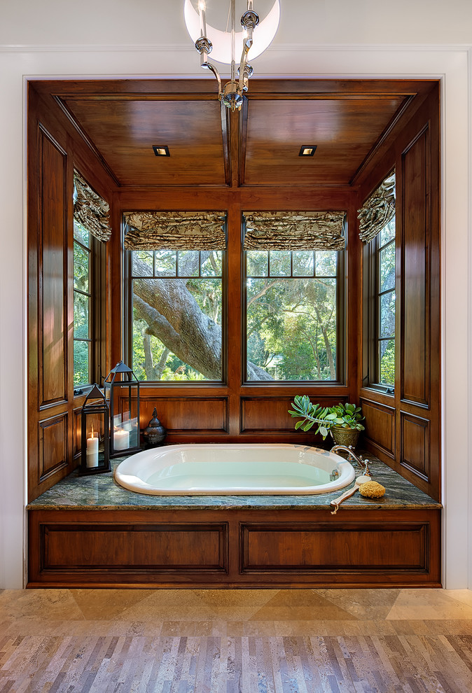 Foto de cuarto de baño tradicional con armarios con paneles con relieve, puertas de armario de madera en tonos medios y bañera encastrada