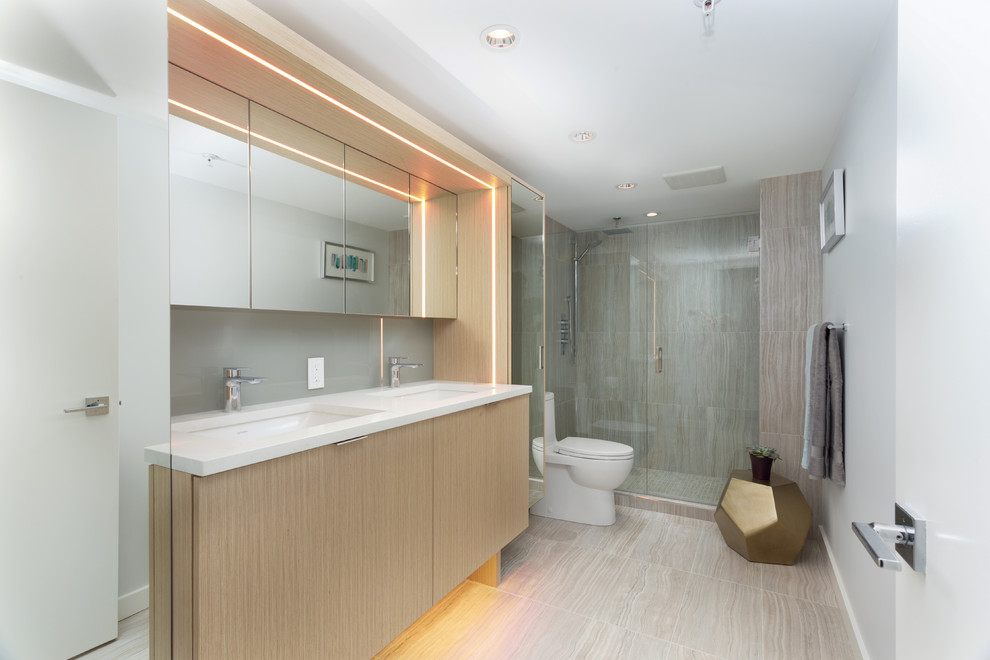 Идея дизайна: главная ванная комната среднего размера в стиле модернизм с плоскими фасадами, бежевыми фасадами, душевой комнатой, унитазом-моноблоком, серой плиткой, плиткой из листового стекла, белыми стенами, полом из керамогранита, врезной раковиной, столешницей из искусственного кварца, бежевым полом, душем с распашными дверями и белой столешницей