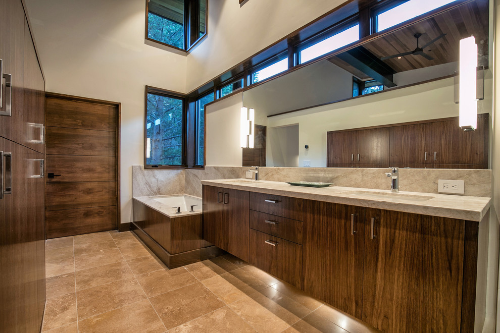 На фото: главная ванная комната в стиле рустика с плоскими фасадами, темными деревянными фасадами, полновстраиваемой ванной, бежевой плиткой, белыми стенами, врезной раковиной, бежевым полом и бежевой столешницей с