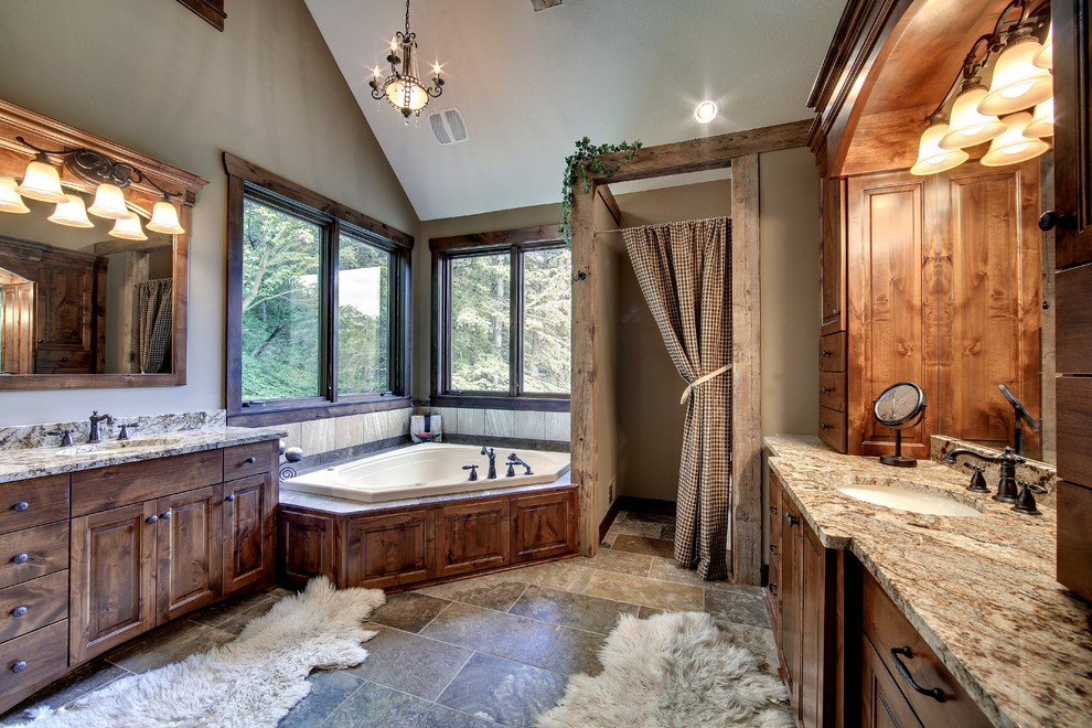 Inspiration for a craftsman brown floor corner bathtub remodel in Minneapolis with raised-panel cabinets, brown cabinets, brown walls, an undermount sink and granite countertops