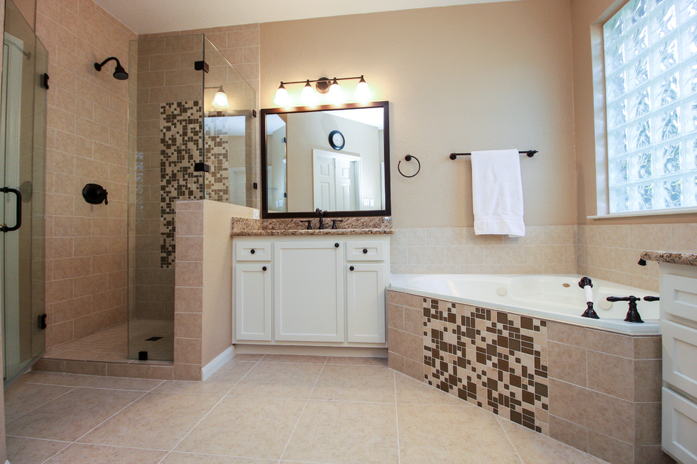 Inredning av ett klassiskt stort en-suite badrum, med skåp i shakerstil, vita skåp, ett hörnbadkar, en hörndusch, beige kakel, keramikplattor, beige väggar, klinkergolv i keramik, ett undermonterad handfat och granitbänkskiva