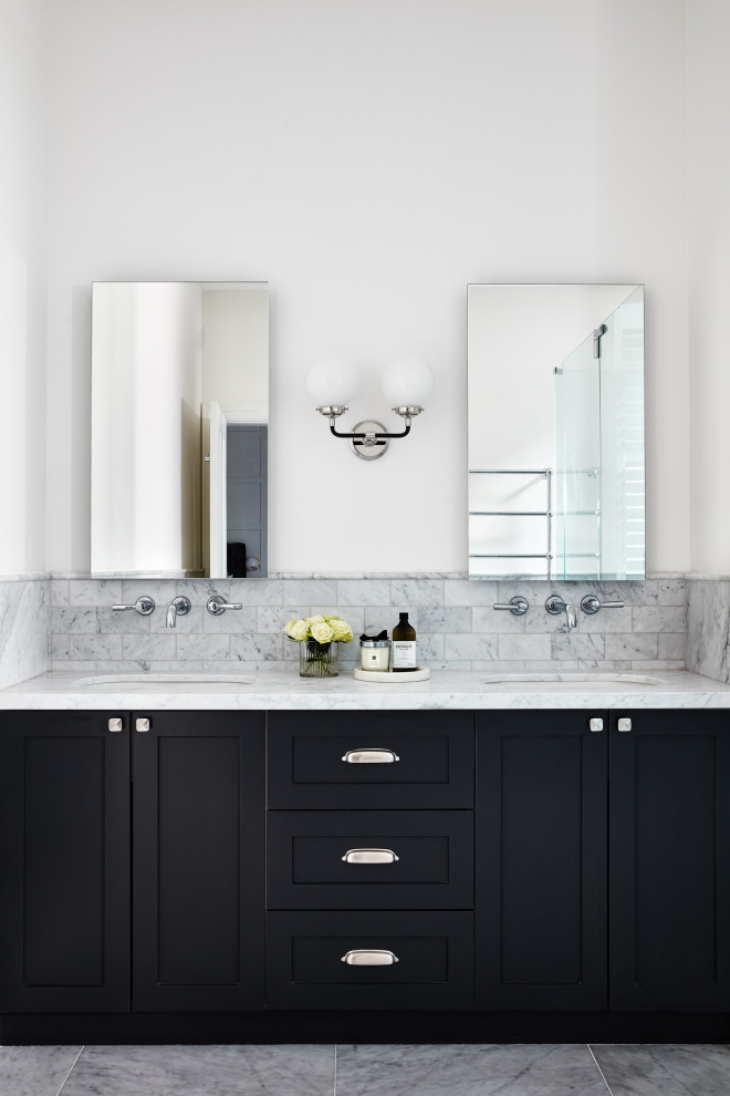 Exemple d'une salle de bain chic avec un placard à porte shaker, des portes de placard noires, du carrelage en marbre, un sol en marbre, un plan de toilette en marbre, meuble double vasque et meuble-lavabo encastré.