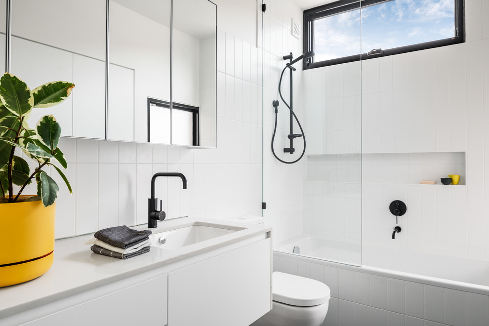 Exempel på ett modernt vit vitt badrum med dusch, med släta luckor, vita skåp, ett platsbyggt badkar, en dusch/badkar-kombination, vit kakel, vita väggar, ett undermonterad handfat och med dusch som är öppen