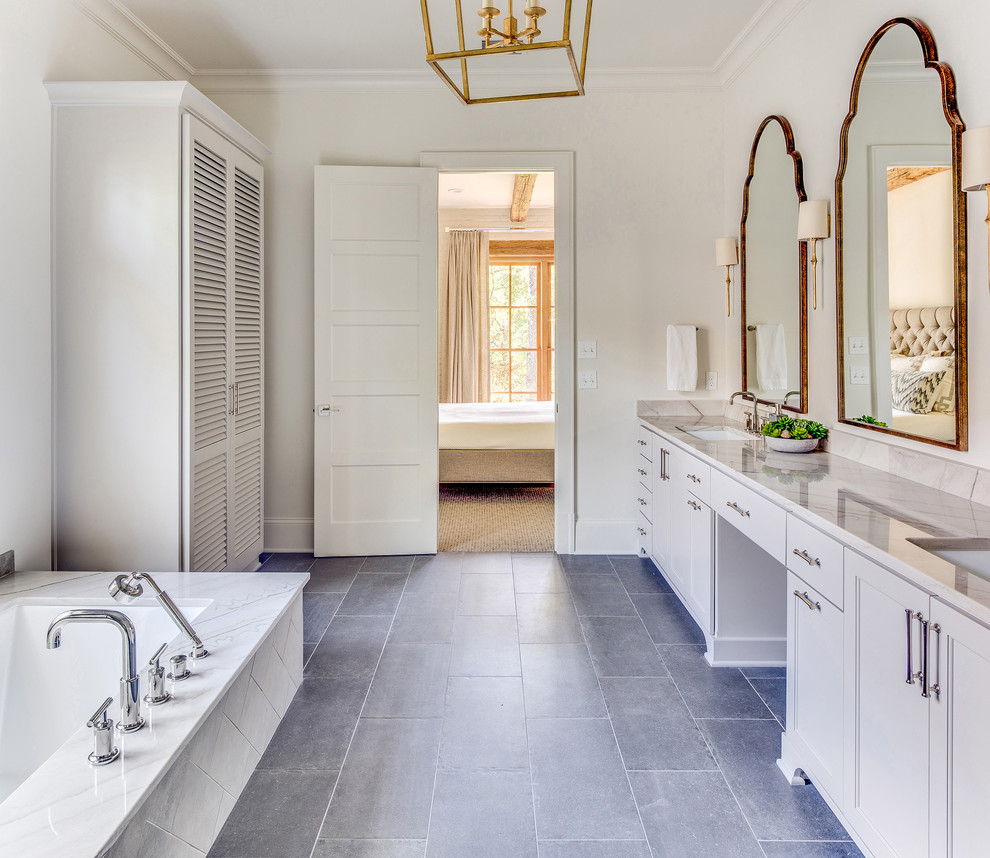 Inspiration pour une salle de bain principale traditionnelle avec des portes de placard grises, une baignoire encastrée, un mur blanc, un lavabo encastré, un sol gris et un plan de toilette gris.