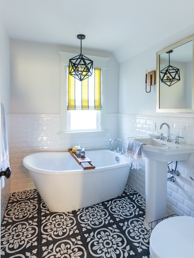 Exempel på ett litet klassiskt badrum med dusch, med ett fristående badkar, en toalettstol med separat cisternkåpa, svart och vit kakel, cementkakel, vita väggar, cementgolv och ett piedestal handfat