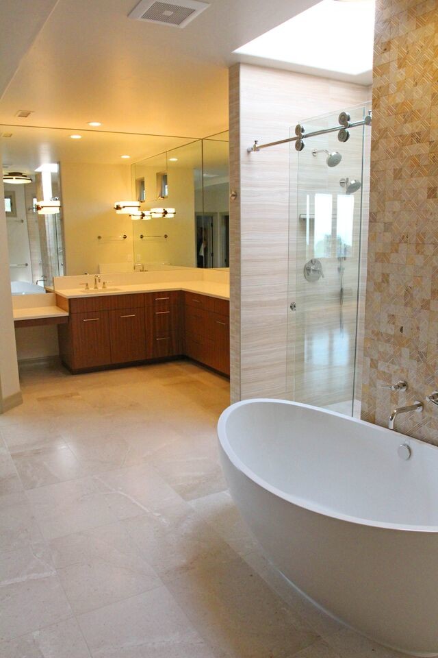Exemple d'une grande salle de bain principale tendance en bois brun avec un placard à porte plane, une baignoire indépendante, un mur beige, une douche double, un lavabo encastré, un sol en travertin, un plan de toilette en surface solide, un sol beige, une cabine de douche à porte coulissante, un carrelage beige et des carreaux de céramique.