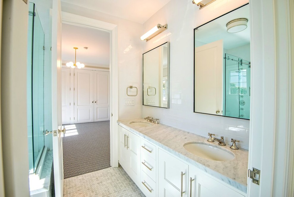This is an example of a large traditional ensuite bathroom in Los Angeles with white walls, vinyl flooring, recessed-panel cabinets, white cabinets, an alcove shower, white tiles, metro tiles, a submerged sink and marble worktops.