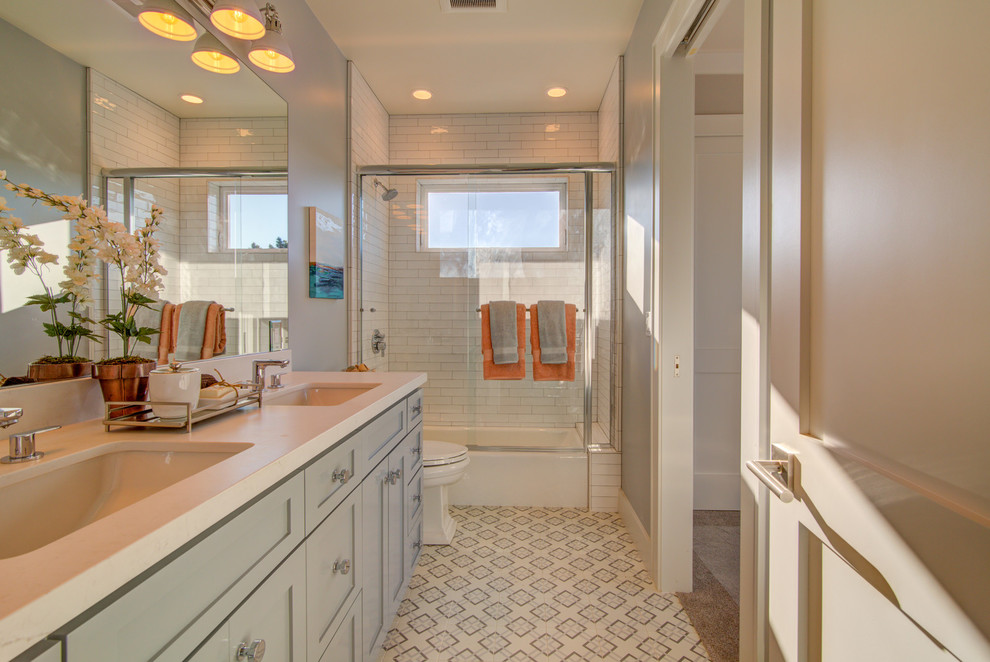 Ispirazione per una stanza da bagno con doccia tradizionale con ante in stile shaker, ante grigie, pareti grigie, lavabo sottopiano, pavimento multicolore e top bianco