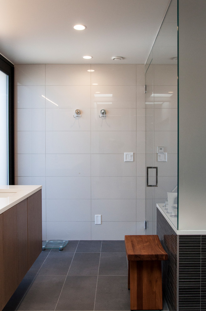 Exemple d'une salle de bain principale moderne en bois brun de taille moyenne avec un placard à porte plane, un bain japonais, une douche à l'italienne, WC suspendus, un carrelage gris, des carreaux de céramique, un mur blanc, un sol en carrelage de céramique, un lavabo encastré et un plan de toilette en quartz modifié.
