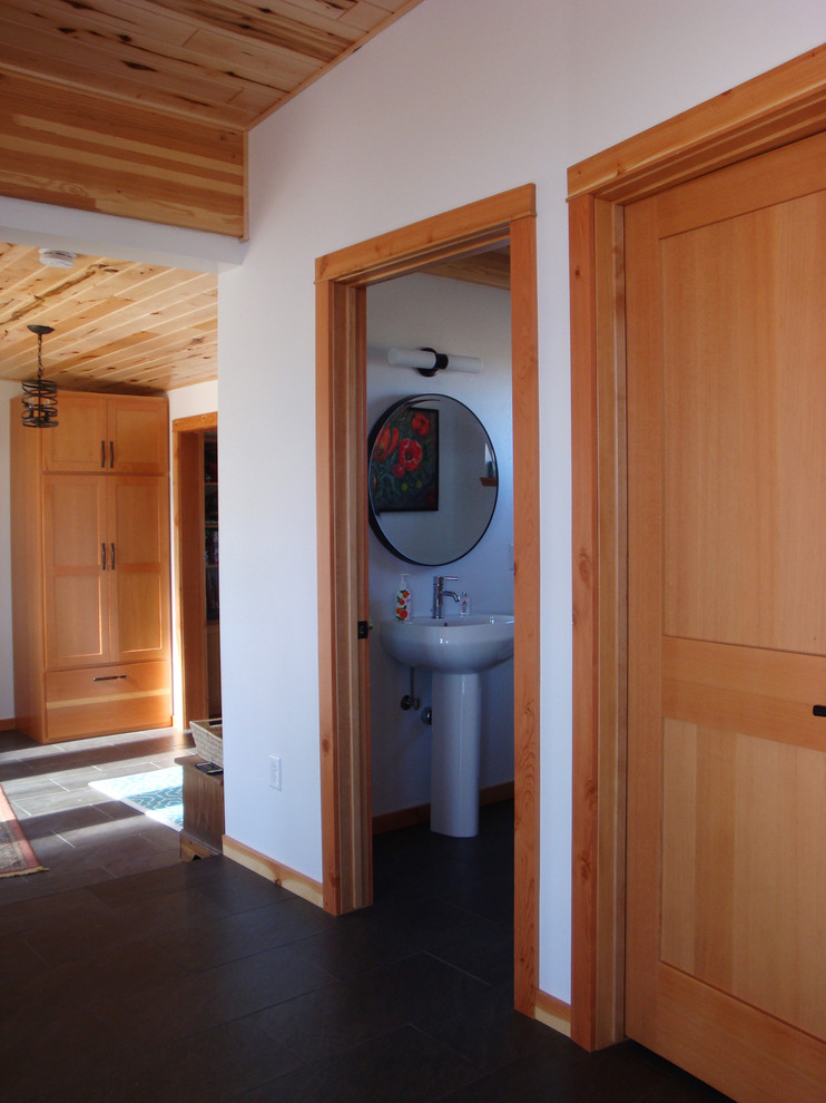Exemple d'une salle d'eau moderne de taille moyenne avec un carrelage noir, des carreaux de céramique, un mur blanc, un sol en carrelage de céramique et un lavabo de ferme.