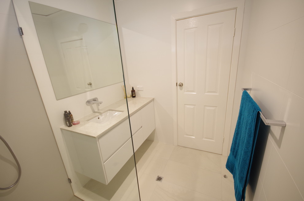 Bathroom - mid-sized contemporary master white tile and porcelain tile porcelain tile and yellow floor bathroom idea in Perth with furniture-like cabinets, white cabinets, white walls, an undermount sink, quartz countertops and white countertops